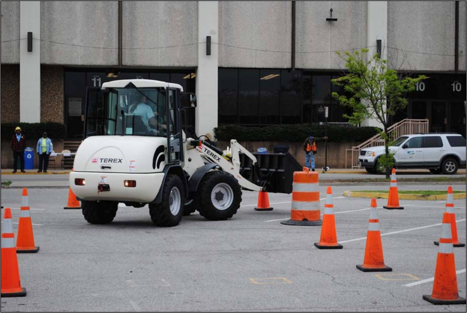 A participant from a neighboring locality maneuvers the front end loader through the obstacle course.